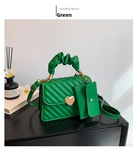 Detail of green quilted texture handbag with gold heart buckle and matching coin purse