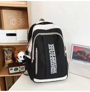 Detail of color block nylon backpack with multi-pocket design and panda charm