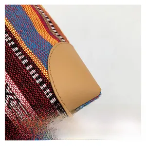 Close-up of bohemian striped jacquard fabric with reinforced khaki leather corner stitching