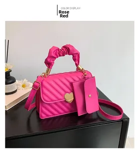 Detail of rose red quilted handbag with golden heart clasp and cloud pleat handle