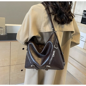 Détail d'un sac hobo en cuir PU marron avec fermetures éclair et boucles argentées