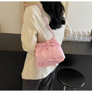 Vue détaillée du sac seau rose avec cordon de serrage, nœuds et bandoulière chaîne