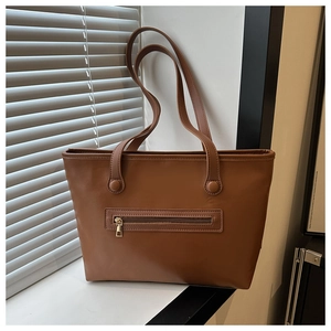 Vista dettagliata della borsa tote in pelle PU marrone scuro con tasca frontale a zip