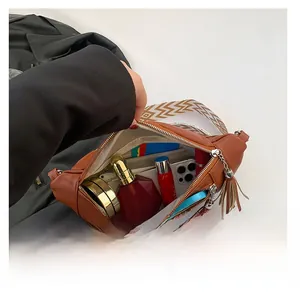 Vue de dessus d'un sac bandoulière marron montrant la capacité pour mobile et maquillage