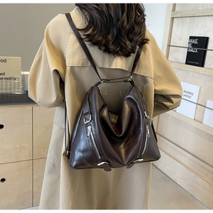 Sac à dos en cuir souple marron foncé porté par un mannequin dans un studio moderne