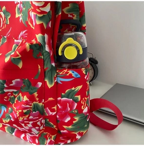Detail of the side pocket on a floral backpack showing water bottle storage capacity