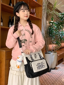 Chic black and white student messenger bag with cute plush duck charm and stripe design