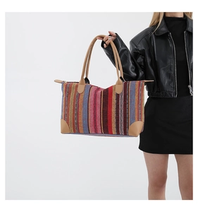Detail of colorful woven tote bag featuring ethnic patterns and brown leather handles