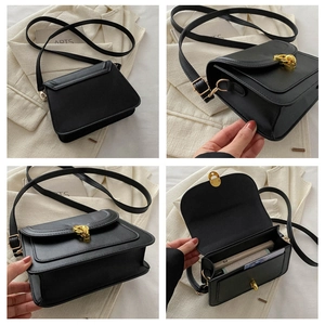 Detail view of black matte leather crossbody bag with gold twisted magnetic closure