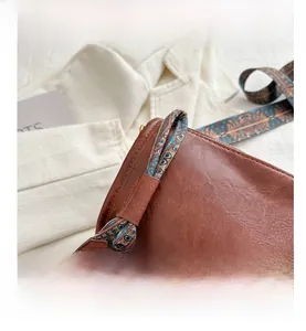 Détail du cabas marron vintage avec bandoulière ethnique tissée et rivets métalliques