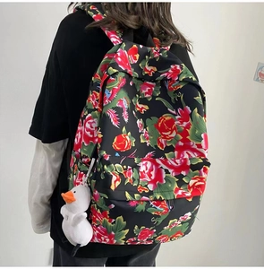 Detailed side view of ethnic floral backpack with white duck pendant and large capacity