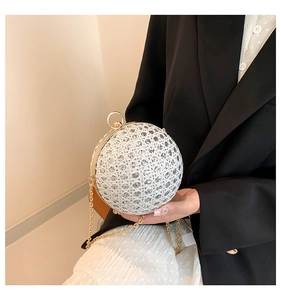 Macro shot of silver sphere evening bag with rhinestone mesh and golden ring handle