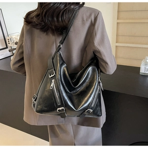 Détail du sac hobo noir avec fermetures éclair argentées et texture cuir souple