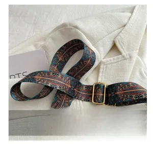 Détail de la bandoulière réglable à motifs géométriques et boucle dorée pour sacs à main
