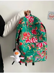 Detailed view of green floral backpack with ethnic patterns and a white plush duck charm