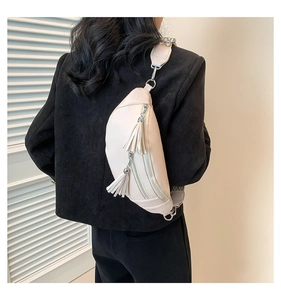 Détail du sac ceinture en cuir crème avec doubles glands et bandoulière à motifs