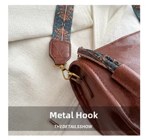 Détails d'un sac en cuir marron avec sangle bohème et crochets dorés vintage