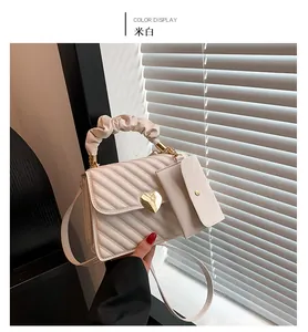 Detail of off-white crossbody bag with heart lock, scrunchie handle, and mini coin purse