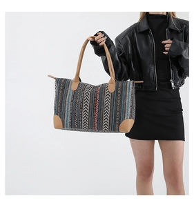 Detailed view of ethnic geometric jacquard fabric and brown leather handle on large tote bag