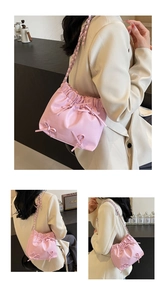 Vue détaillée du sac seau rose avec nœuds, fermeture à cordon et bandoulière en chaîne