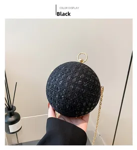Close-up of black spherical evening bag with woven texture, sequins and gold ring clasp