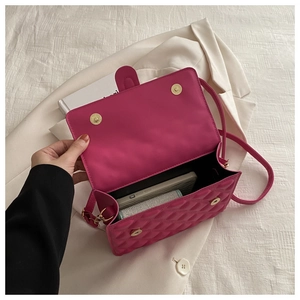 Detailed interior of rose red quilted crossbody bag with golden magnetic snap closure