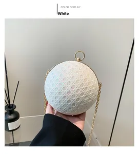 Detail of white spherical evening bag featuring glitter sequins and golden chain strap