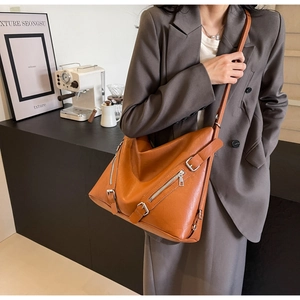 Détail du sac cabas en cuir grainé marron avec fermetures éclair et bandoulière large