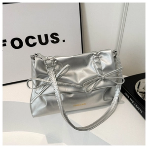 Detail of silver metallic tote bag featuring pleated design and decorative twin bows