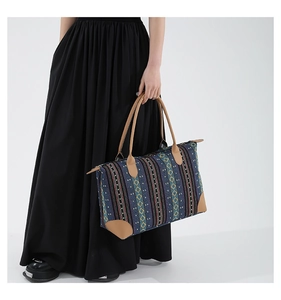 Close-up of ethnic geometric pattern tote bag with blue woven fabric and leather handles