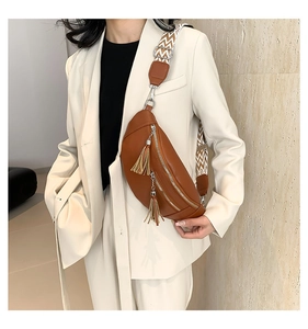Détail du sac banane en cuir caramel avec fermeture à gland et bandoulière à motifs
