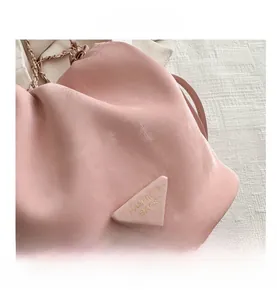 Detail shot of the pink leather texture and the iconic triangle logo on the bucket bag