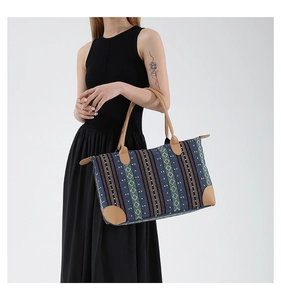Detailed close-up of woven jacquard tote bag with ethnic geometric pattern and leather trim