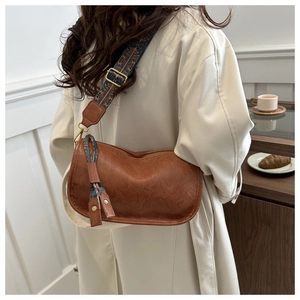 Sac bandoulière marron lune avec bandoulière ethnique porté sur manteau beige