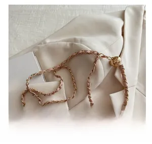 Detailed close-up of pink leather woven gold chain strap with decorative metallic ball