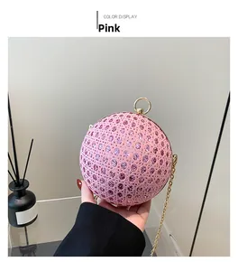 Close-up of pink spherical evening bag with lace surface and sparkling rhinestones