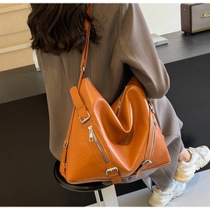 Vue détaillée du grand sac cabas orange-rouge avec fermetures éclair sur un mannequin