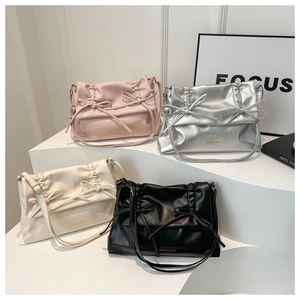 Detail of four colorful tote bags with chic bow designs and stylish pleated textures