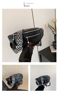 Détail du sac ceinture en cuir grainé noir avec sangle géométrique et pompon décoratif