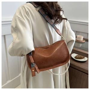 Détail du sac hobo en cuir PU marron avec bandoulière large aux motifs ethniques