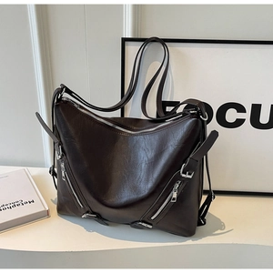 Vue détaillée du sac cabas en cuir marron foncé avec plusieurs fermetures éclair et texture souple
