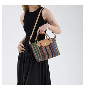 Ethnic style tote bag detail with colorful diamond pattern and brown leather handles