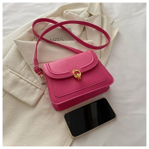 Detail of fuchsia square crossbody bag with gold hardware and adjustable strap