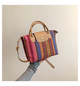 Detail showing the colorful striped woven texture and leather flap of the tote bag