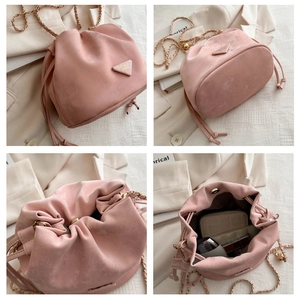 Detail view of pink velvet drawstring bucket bag with gold chain strap and inner storage