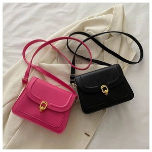 Close-up of matte PU leather crossbody bags in rose red and black with gold ring clasps