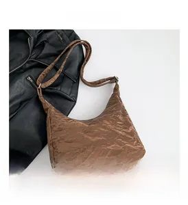 Close-up of brown tote bag showing vintage crinkled texture and adjustable silver buckle