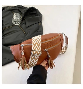 Gros plan du sac ceinture en cuir marron avec pompons et bandoulière géométrique