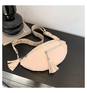Détail du sac bandoulière en cuir beige avec quincaillerie argentée et large sangle tissée
