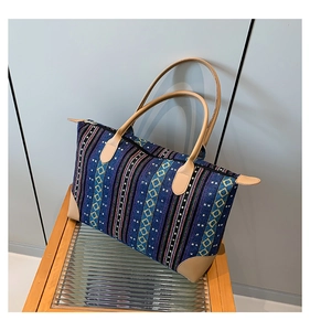 Detailed macro view of woven ethnic patterns and premium faux leather handles on tote bag